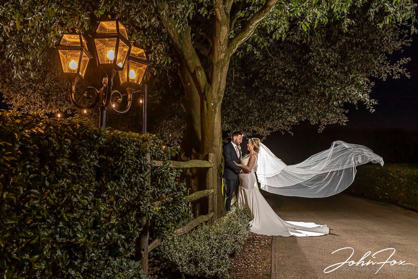 Night image of bride and groom at Fawlsey Hall with brides veil blowing in the wind.