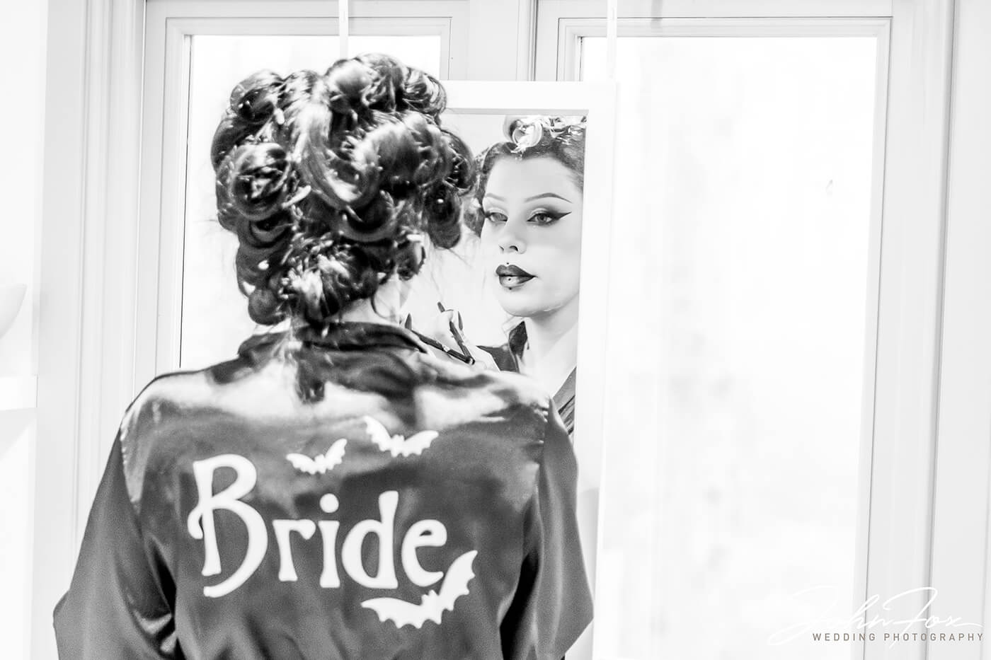 The bride in the mirror with her gothic dressing gown with bats on the back