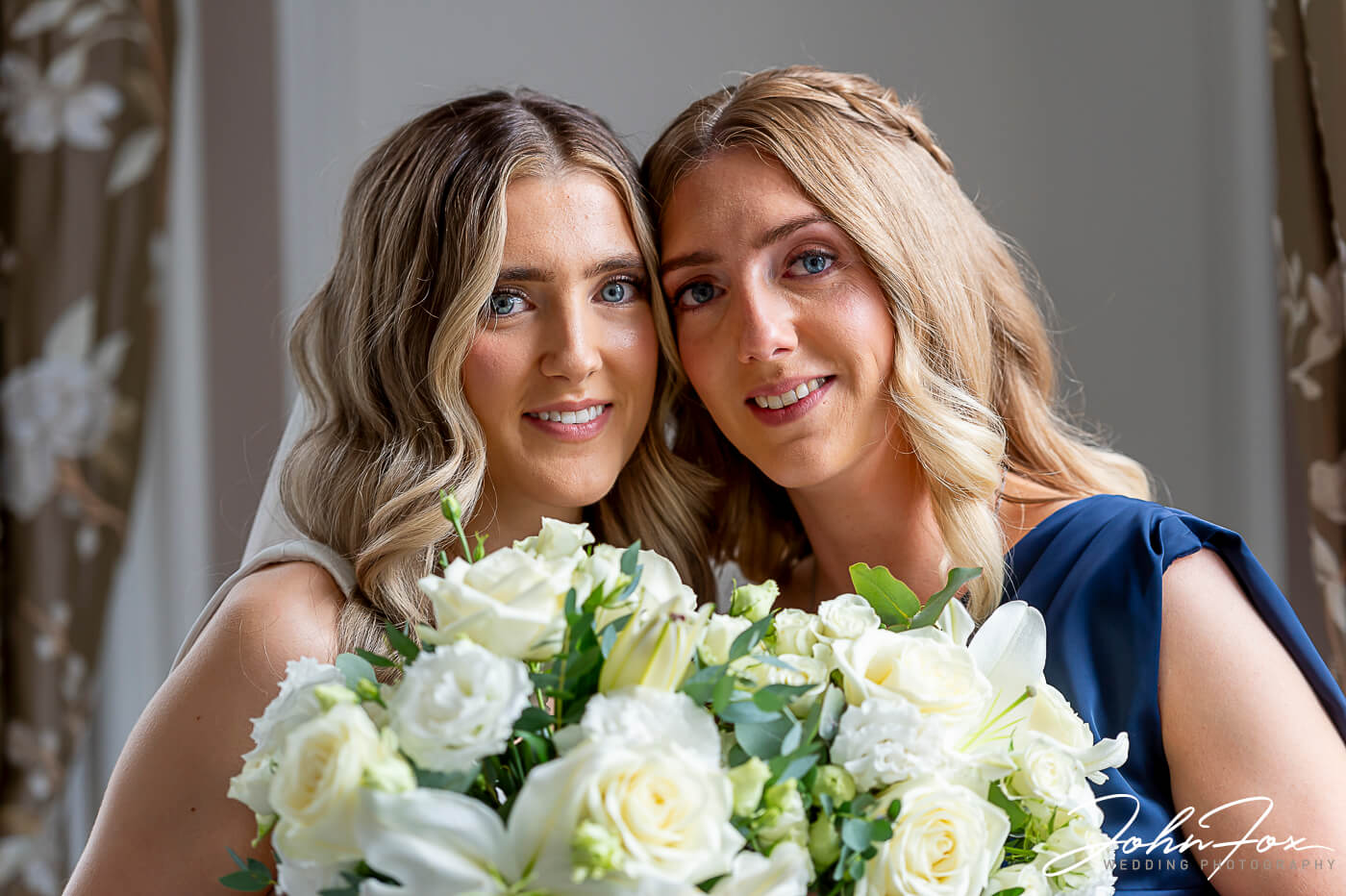 Lorna and her sister with a bouquet of flowers, just before the wedding ceremony at Chicheley Hall in Buckinghamshire