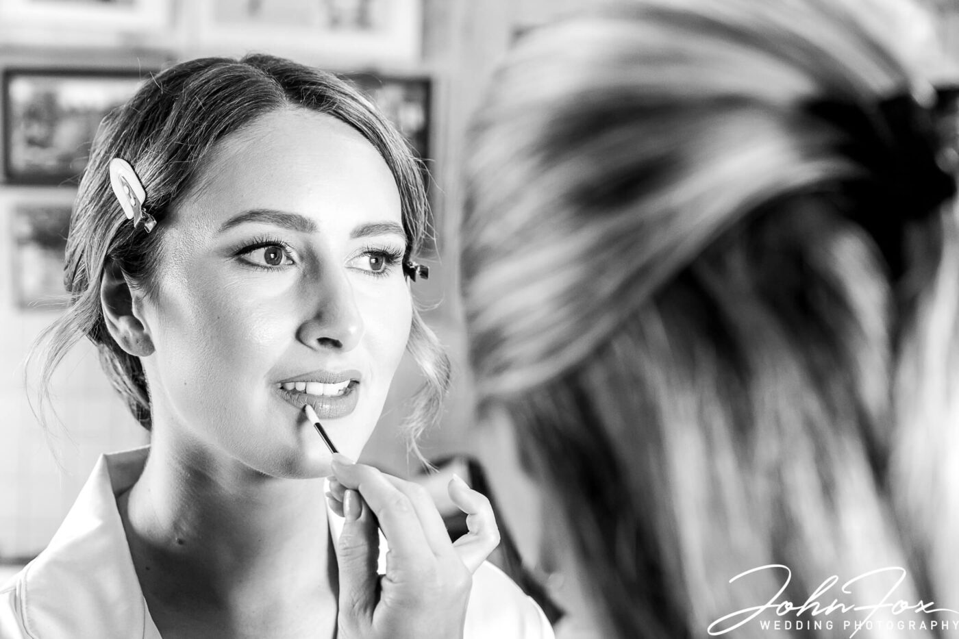 The bride having her makeup preparations. John Fox Wedding Photography on a Derbyshire farm.