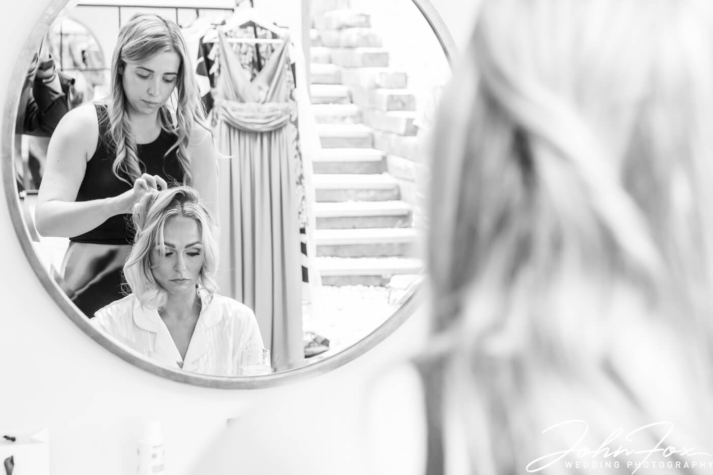 The bride having her hair styled for her wedding at Crockwell Farm. Photo by John Fox Wedding Photography.