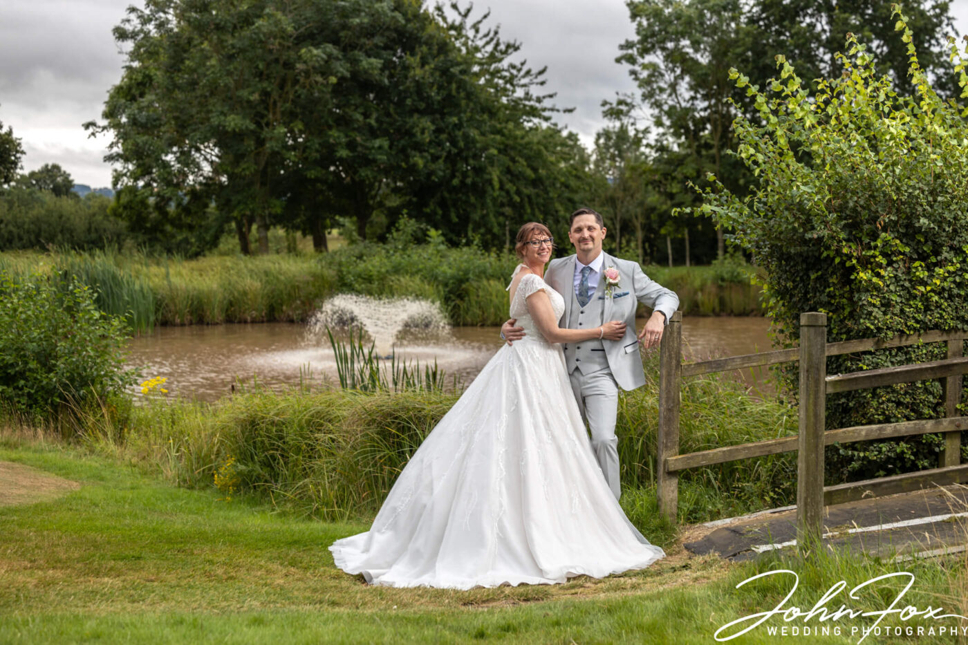 A fountain in the background enhances a perfect moment for the newly wedded couple. Image by John Fox Wedding Photography