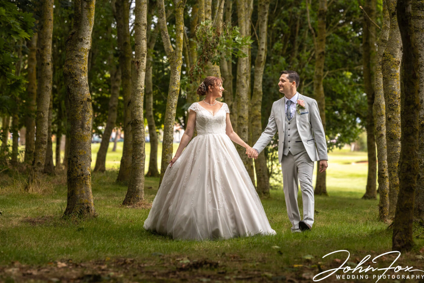 The happy couple walking in the woodlands at The Stratford Park Hotel & Golf Club
